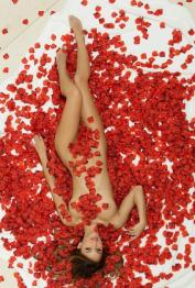 Beautiful girl Uma Jolie poses for a centerfold spread amid red rose petals