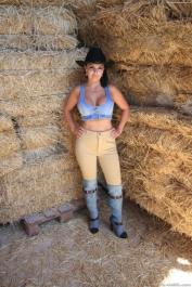 Cowgirl Amanda X displays pierced big tits & huge bubble butt in the stable
