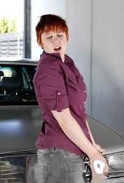 Short haired redhead Lily Cade strips naked atop a car in a garage